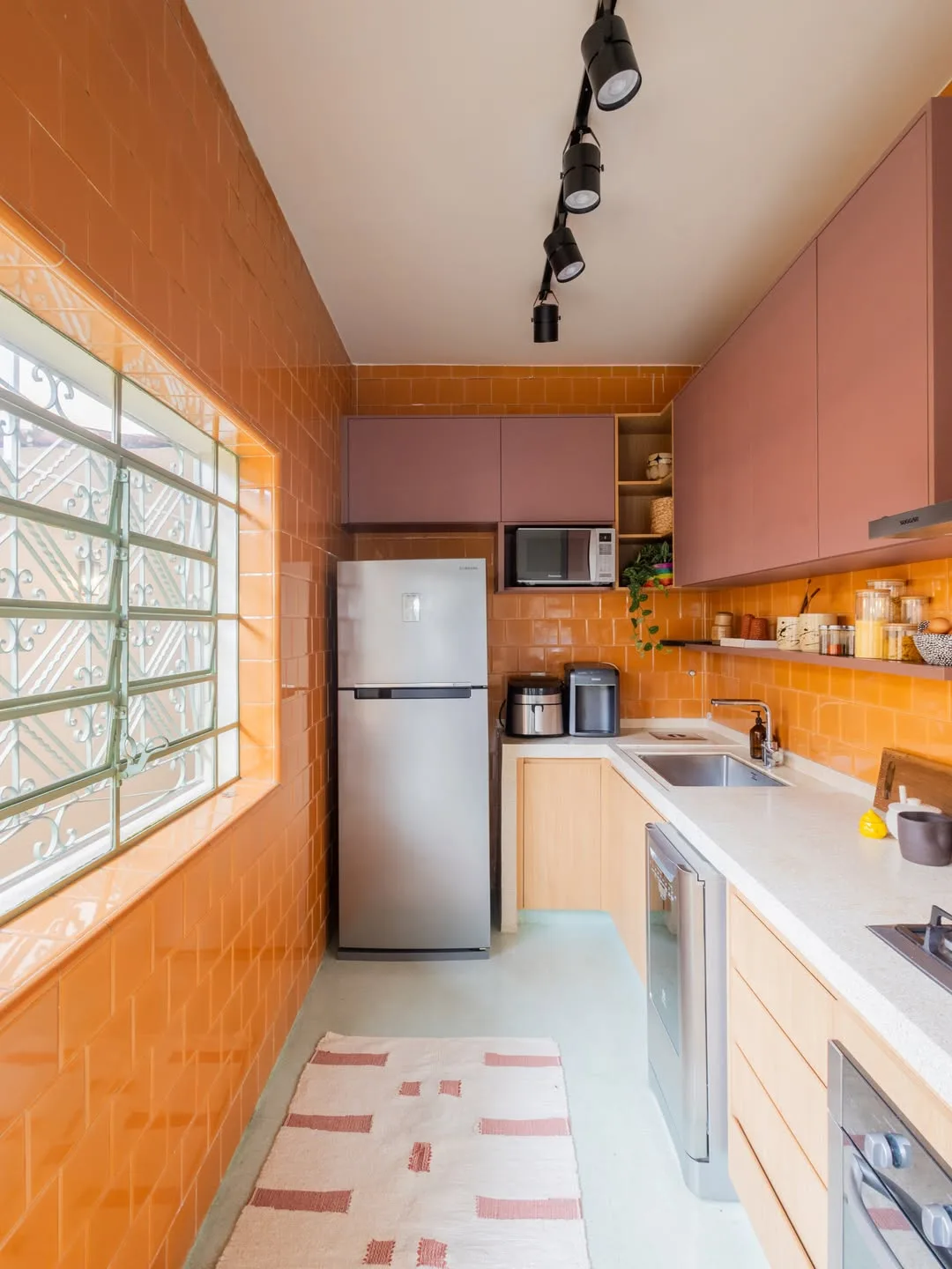 cozinha com azulejos amarelos e armários suspensos rosa