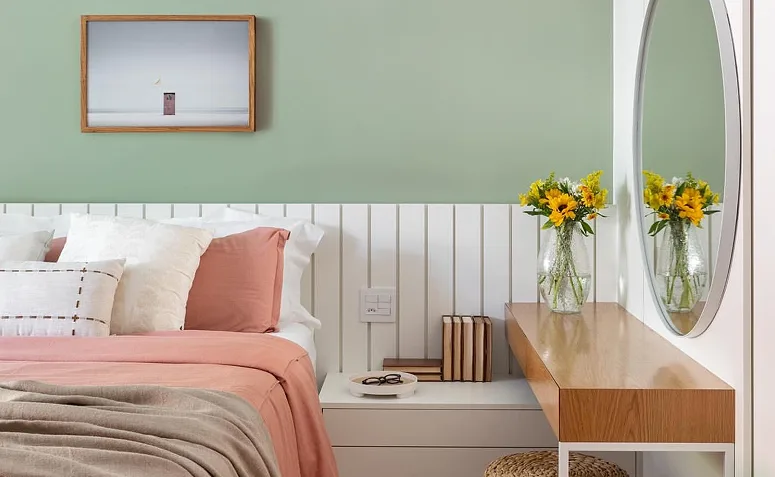 quarto de casal verde com cabeceira branca.
