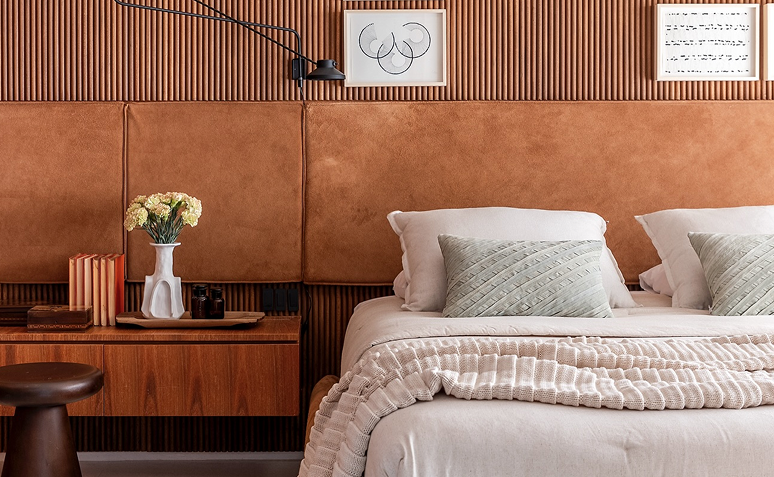 Quarto com decoração com madeira e mantas confortáveis sobre a cama