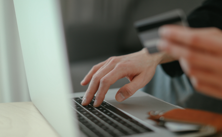 pessoa fazendo compra online com o cartão de crédito na mão
