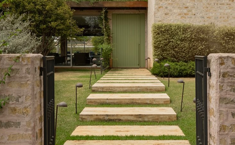 Entrada de casa com porta verde simbolizando cores que favorecem o feng shui.