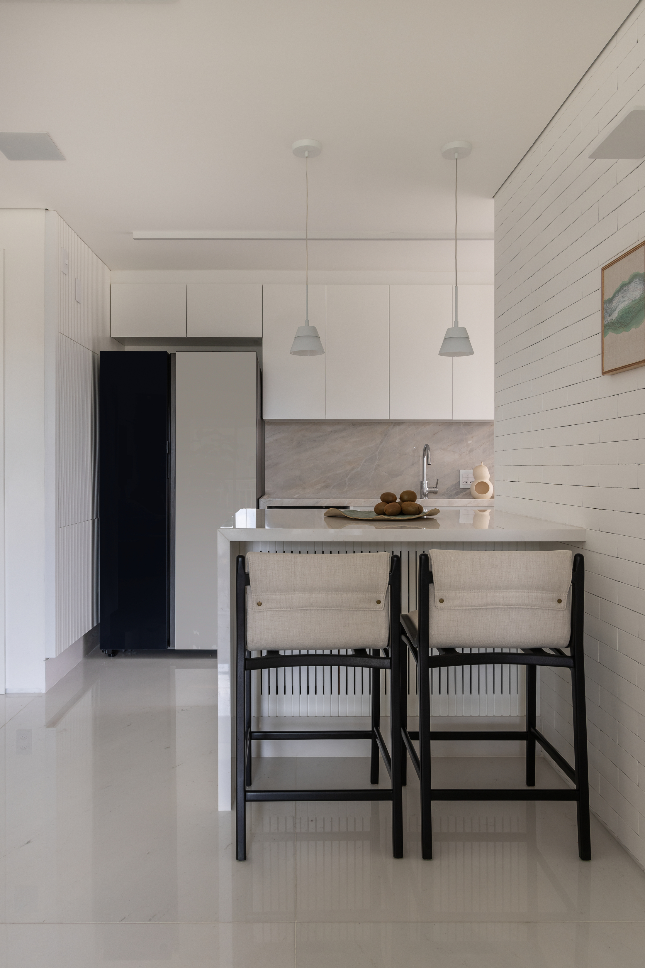 área social integrada com decoração branca e preto em detalhes.