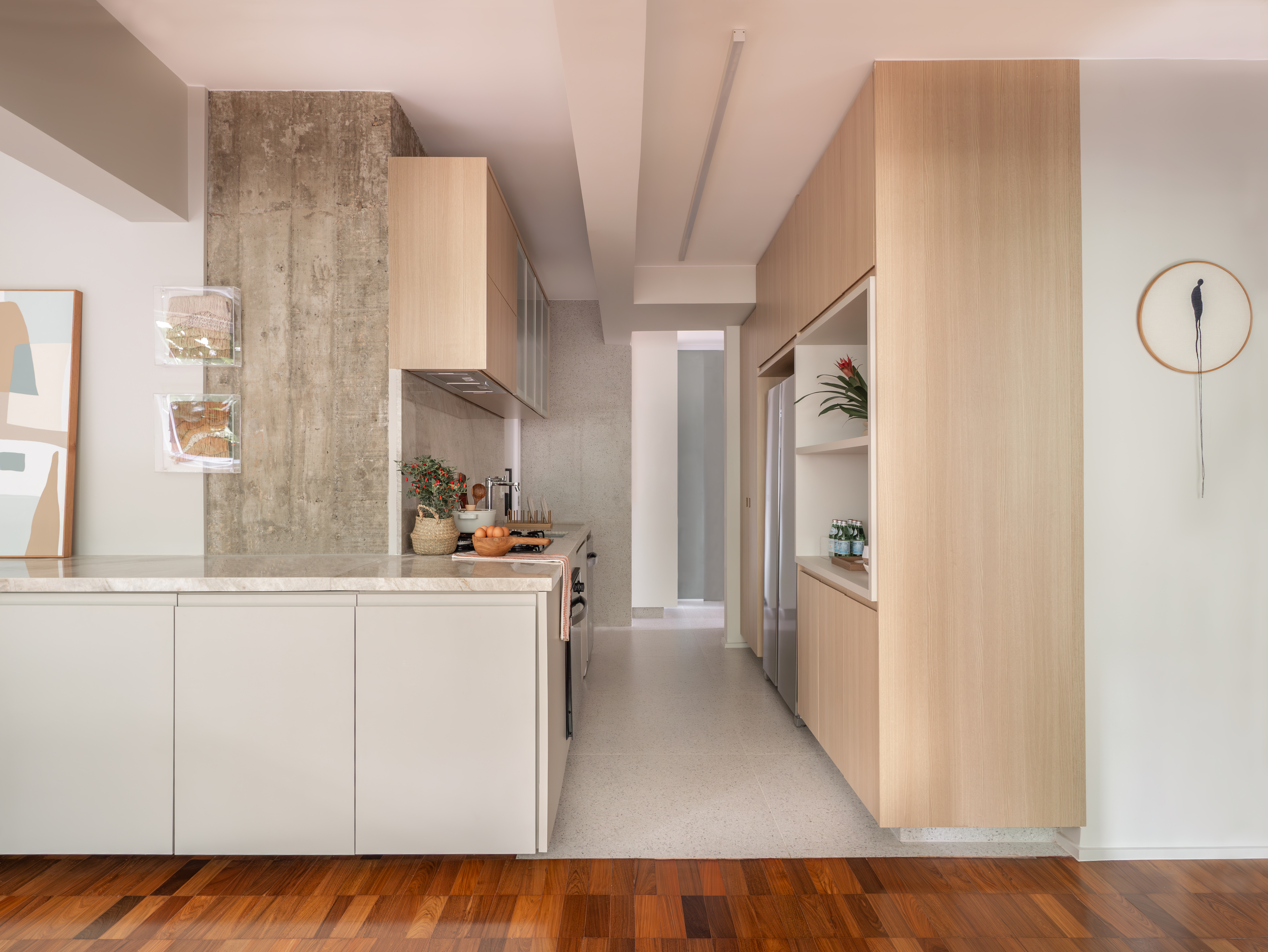 Cozinha integrada à sala de jantar com bancada em L e armários planejados em MDF.