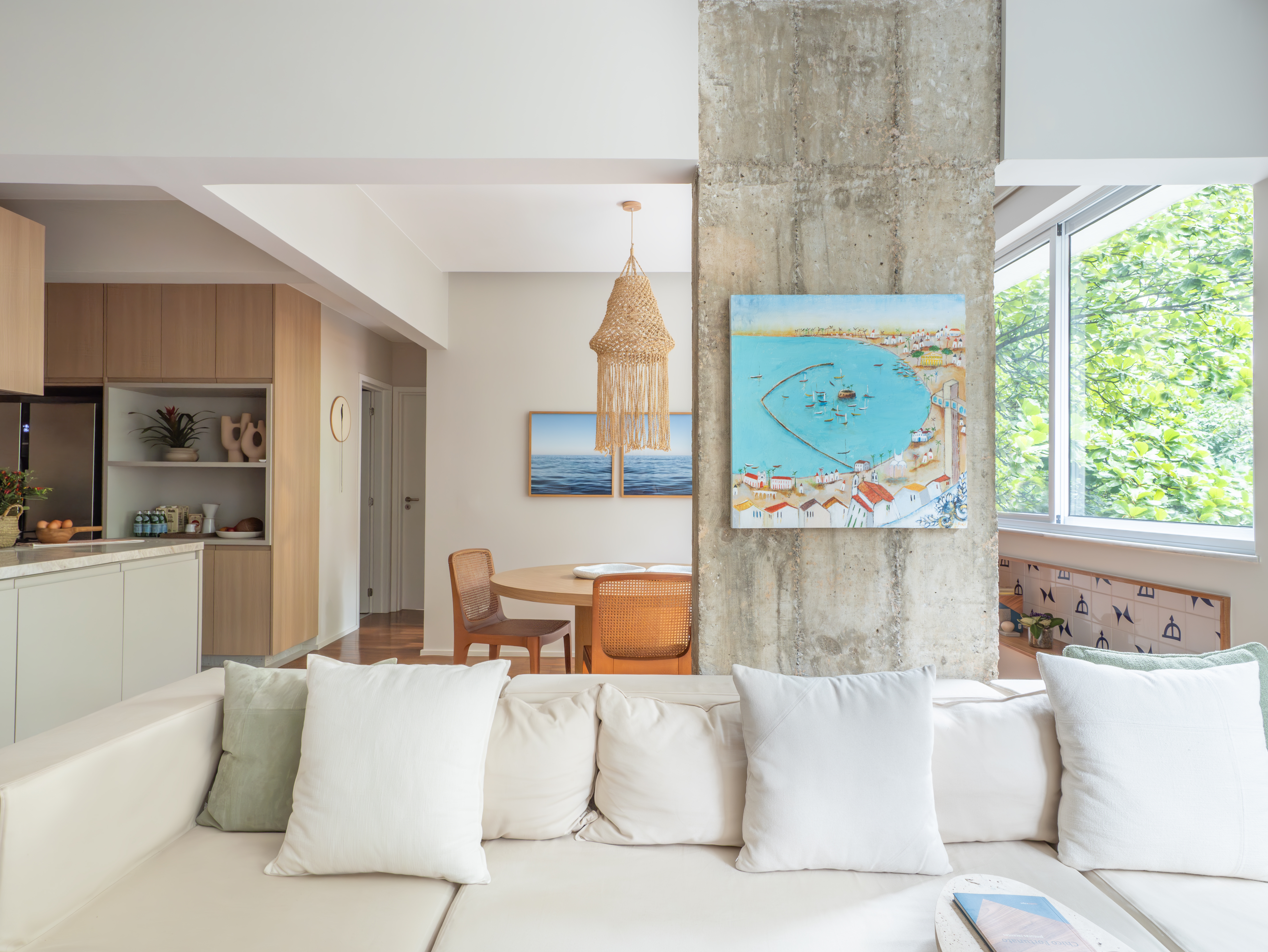 Sala de estar e jantar integradas com iluminação natural e decoração baiana.