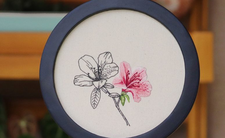 bastidor com flor bordado utilizado na decoração de paredes