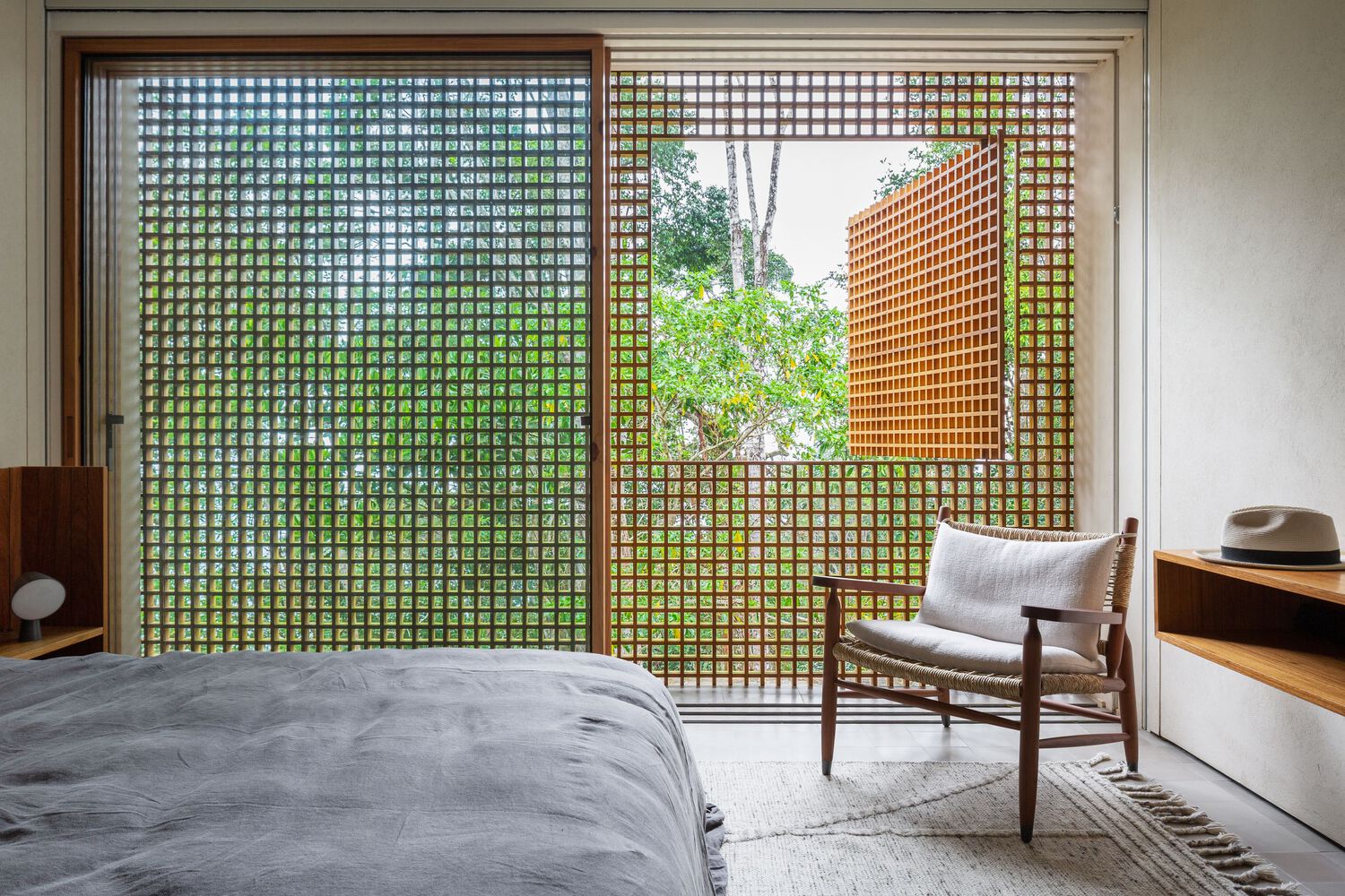 Quarto da Casa Azul cercado por copas de árvores e fechamento em muxarabi de madeira.