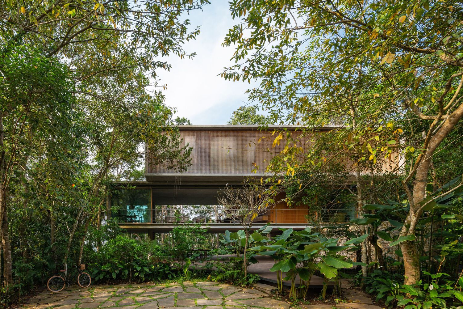 Casa Azul projetada pelo Studio MK27, integrada à mata atlântica com estrutura elevada sobre pilotis.