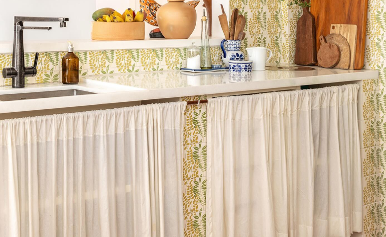 cozinha com cortinas substituindo as portas de armários.