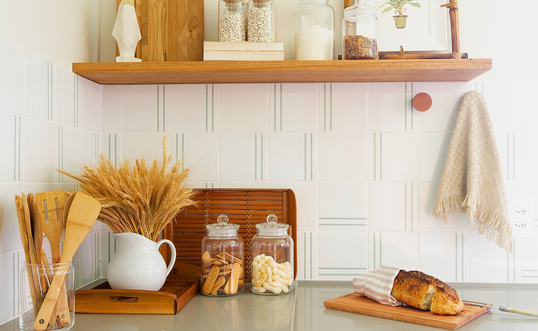 Cozinha clara com prateleiras e potes de vidro sobre a bancada.