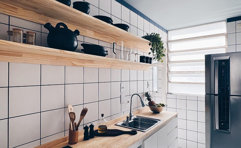 Cozinha com prateleiras exibindo louças e utensílios como parte da decoração.