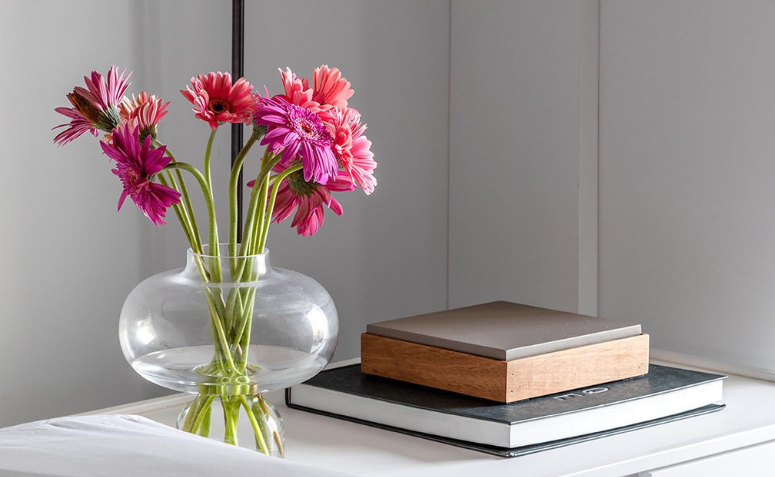 vaso com gérberas em tons de rosa em quarto