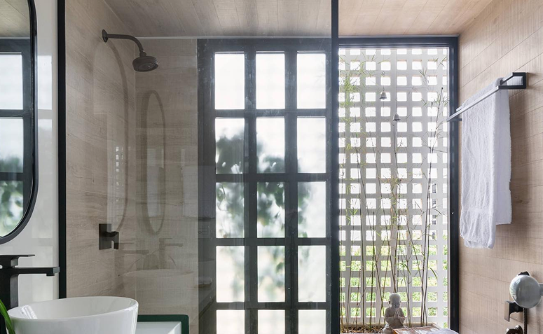 toalha pendurada em banheiro com cobogó e plantas, mostrando ventilação natural para secagem