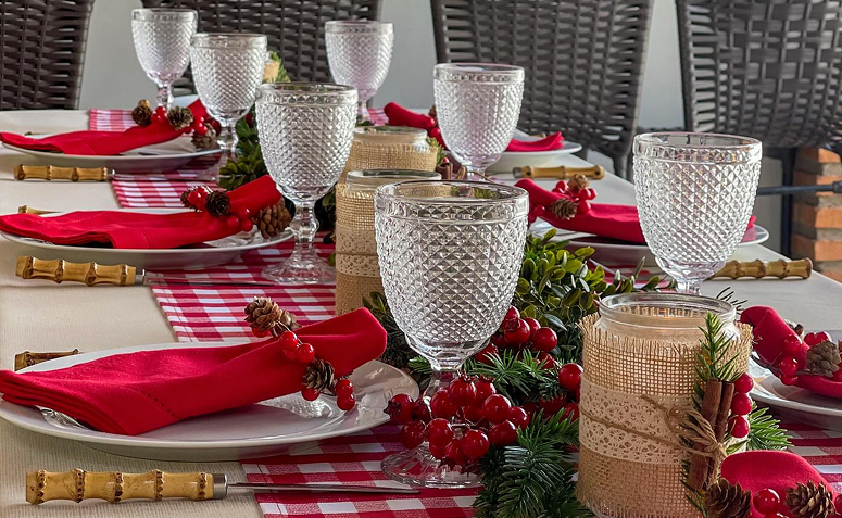 mesa posta simples e charmosa para ceia de Natal econômica, com toalha xadrez vermelha e velas decorativas