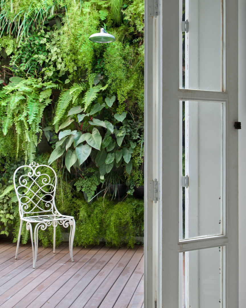 parede verde com jardim vertical e chuveiro externo.