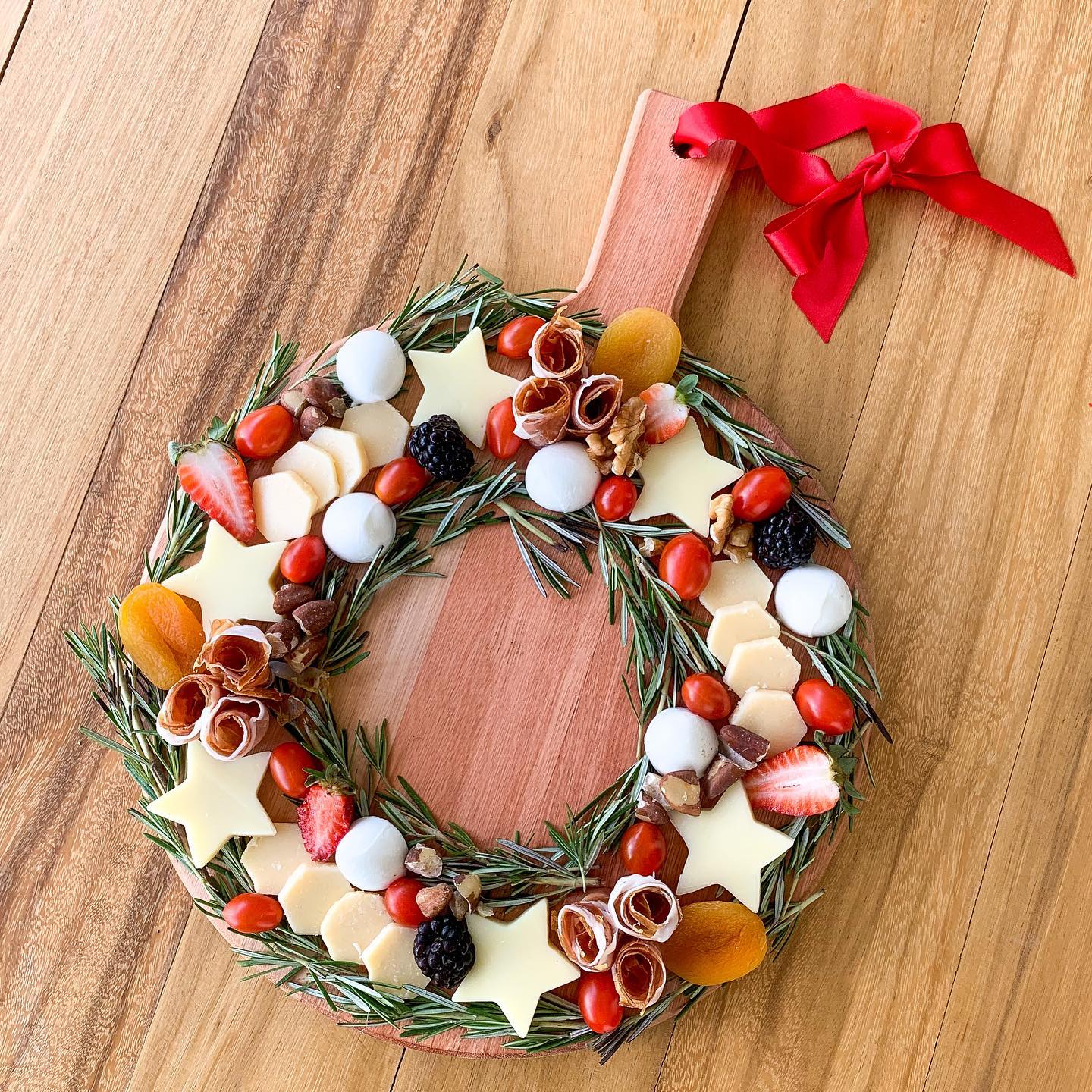 Tábua de guirlanda com queijos e ramos de alecrim para ceia de Natal.