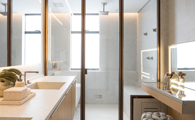 Banheiro de casal com iluminação natural e luz frontal no espelho, garantindo conforto visual para maquiagem e barba.