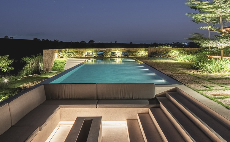piscina residencial iluminada à noite com foco na iluminação subaquática