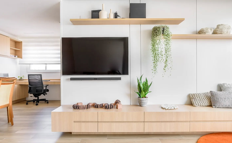 Sala de estar organizada com rack baixo, poucos objetos e decoração neutra