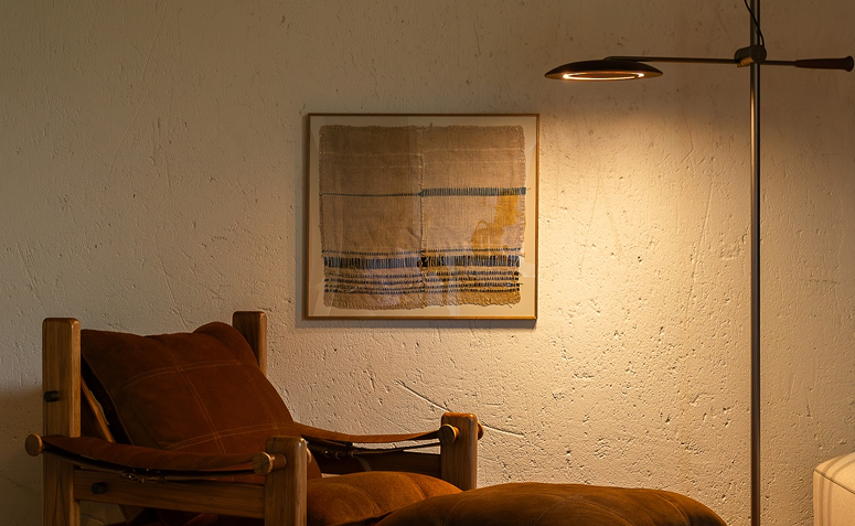 Luminária de piso com luz quente criando iluminação indireta em sala de estar