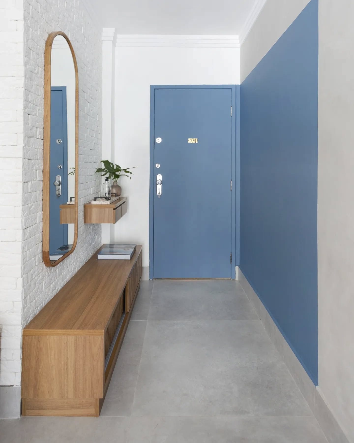 Espelho no corredor ampliando a percepção do espaço e trazendo leveza visual.