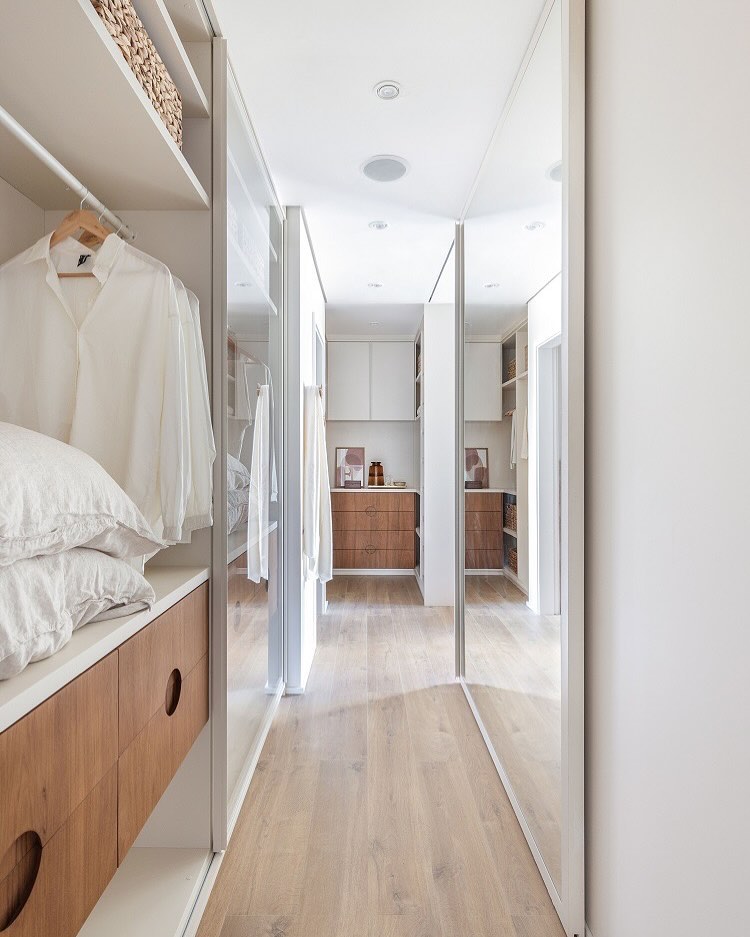 Corredor decorado com espelho simples e funcional.