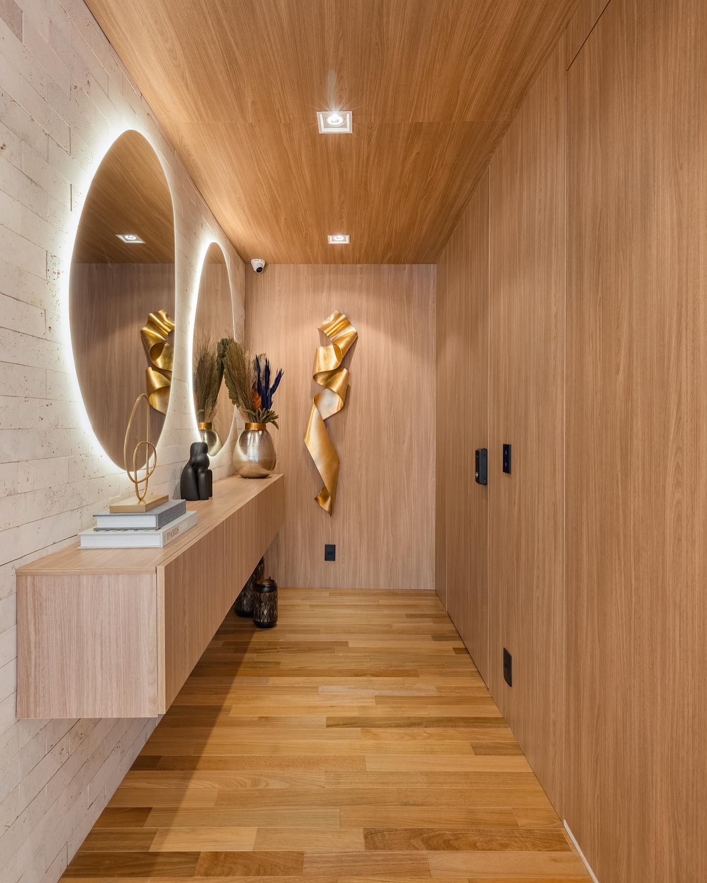 Espelho no corredor com iluminação e deixando o ambiente mais claro.