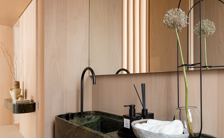 Flor de alho em vaso de vidro usada como detalhe decorativo em banheiro de estilo minimalista