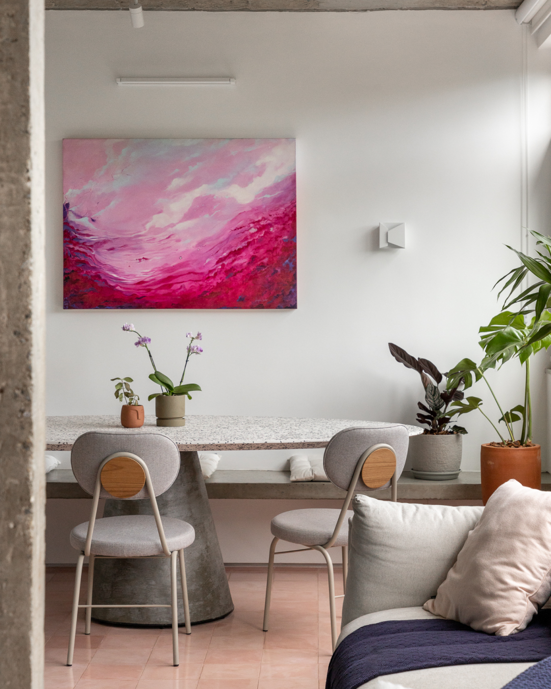 Foto da sala de jantar do apartamento, mostrando o quadro rosa pendurado na parede em evidência.