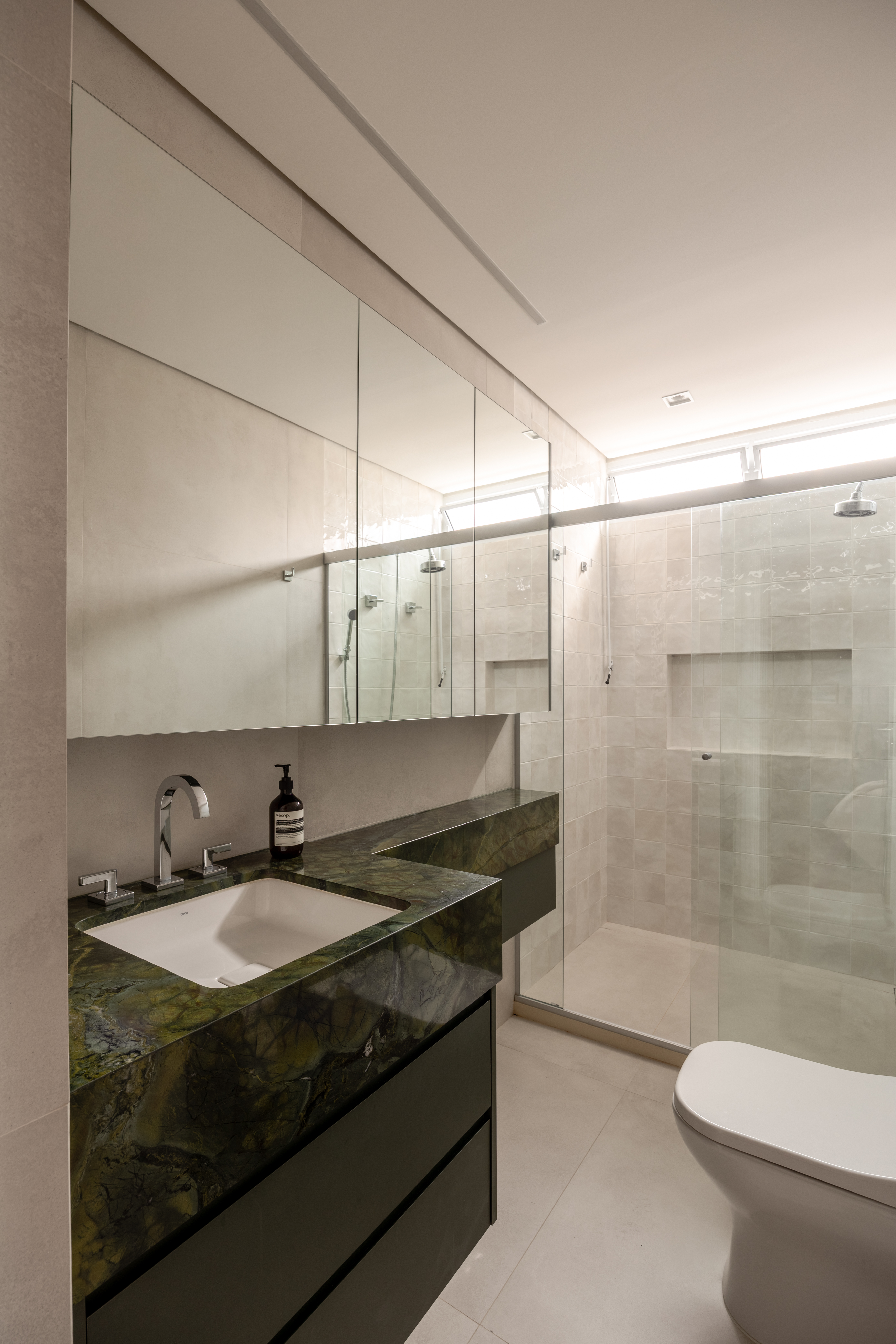 Foto ampla que mostra o banheiro da suíte.