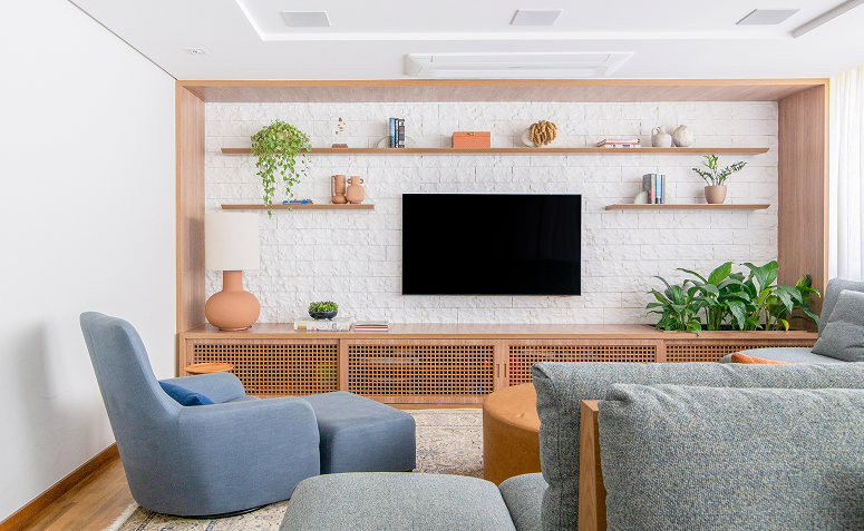 Parede da TV com composição equilibrada entre televisão e decoração na sala