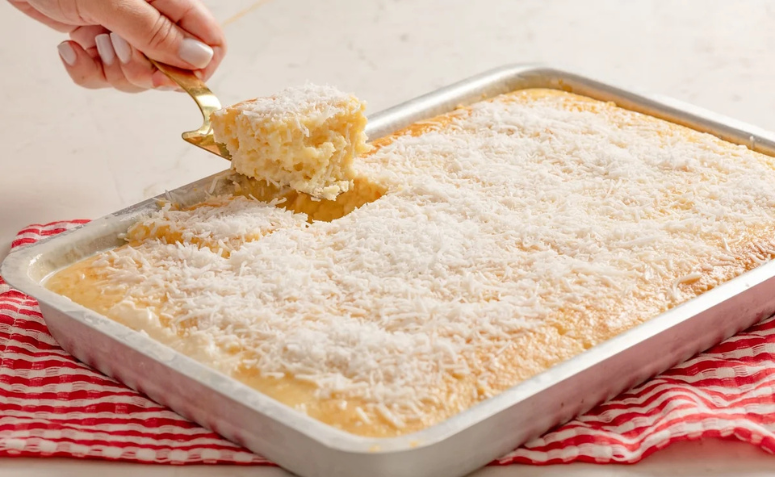 Bolo de coco gelado em uma forma retangular de alumínio.
