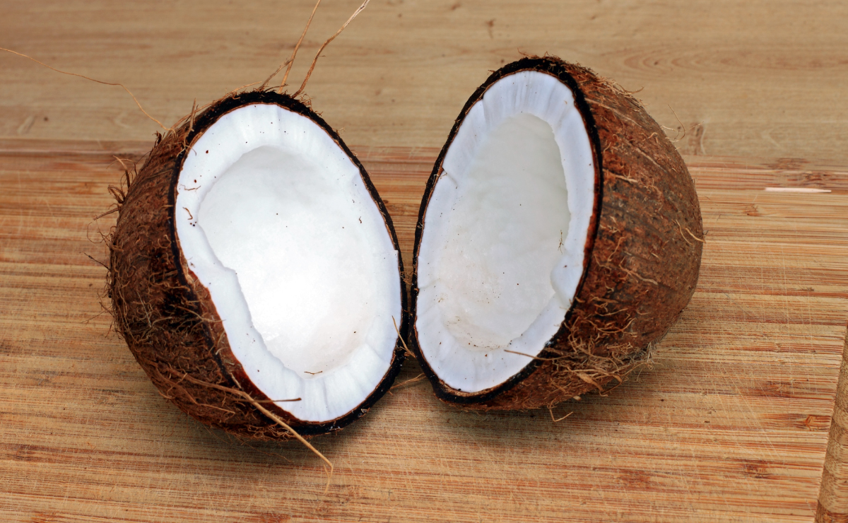 coco seco aberto sobre tábua de madeira em cozinha.