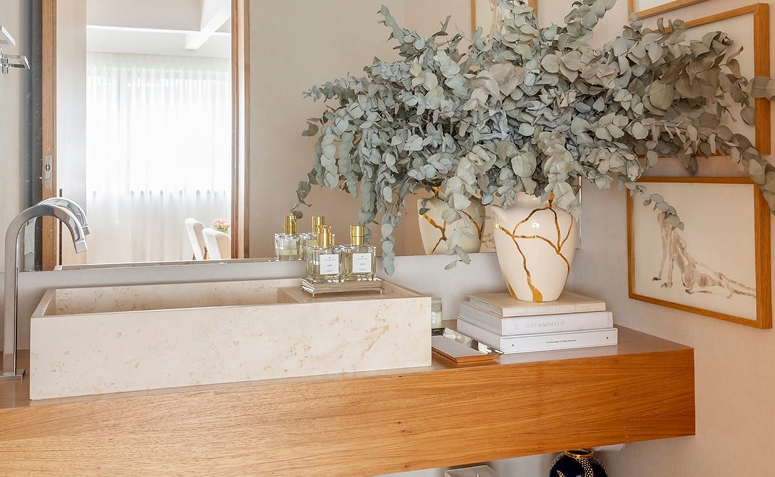 vaso com técnica kintsugi na decoração de banheiro moderno com detalhes em dourado