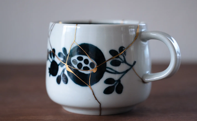 caneca de cerâmica com técnica kintsugi destacando rachaduras douradas após reparo