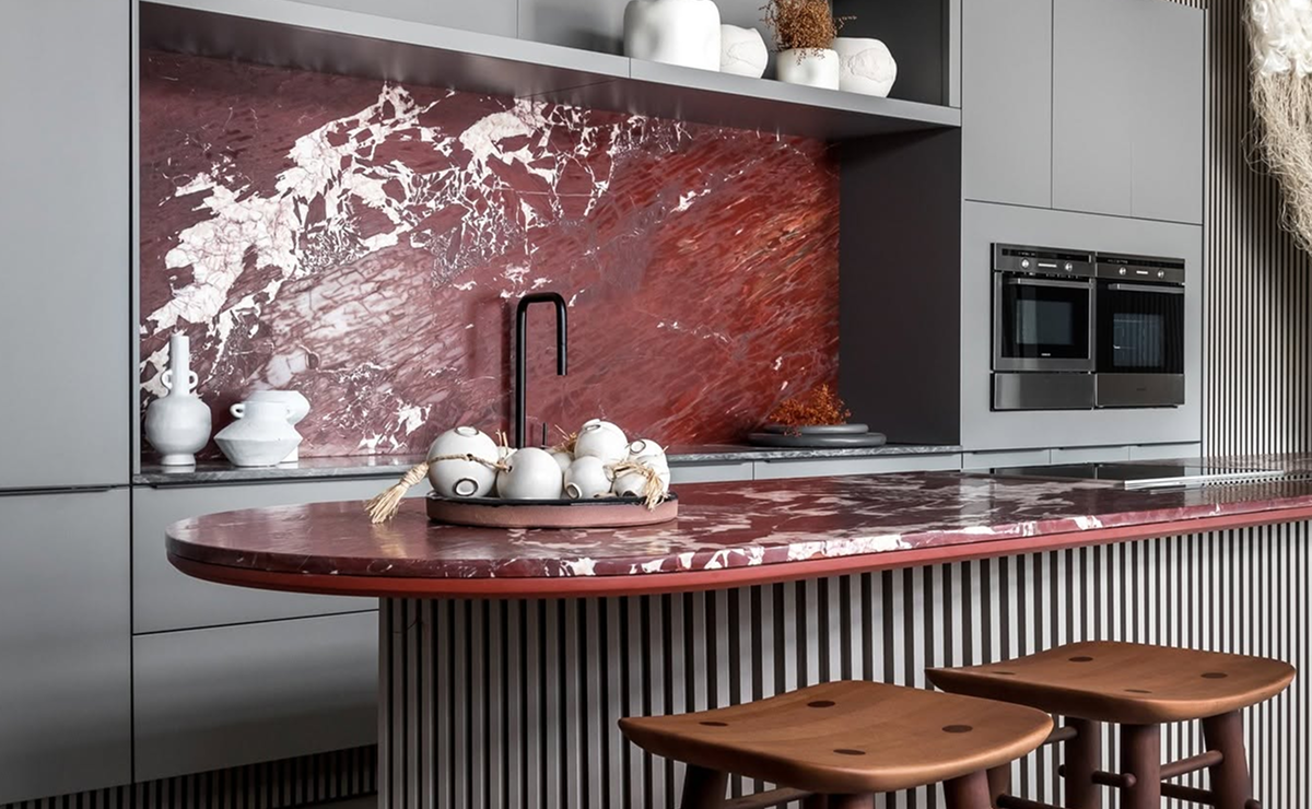 cozinha contemporânea com bancada e painel em mármore vermelho.
