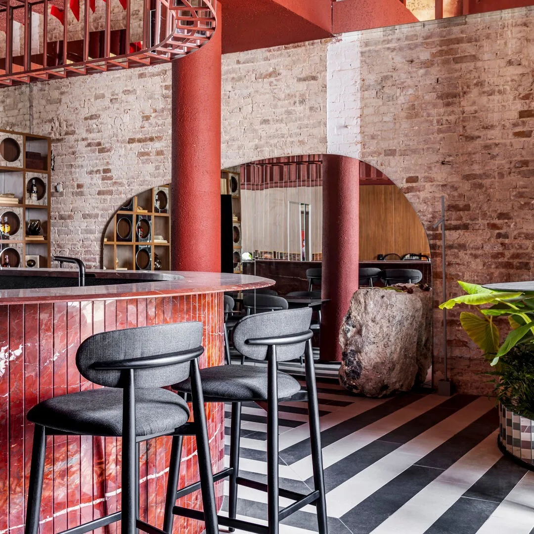 bar de restaurante com revestimento em mármore vermelho.