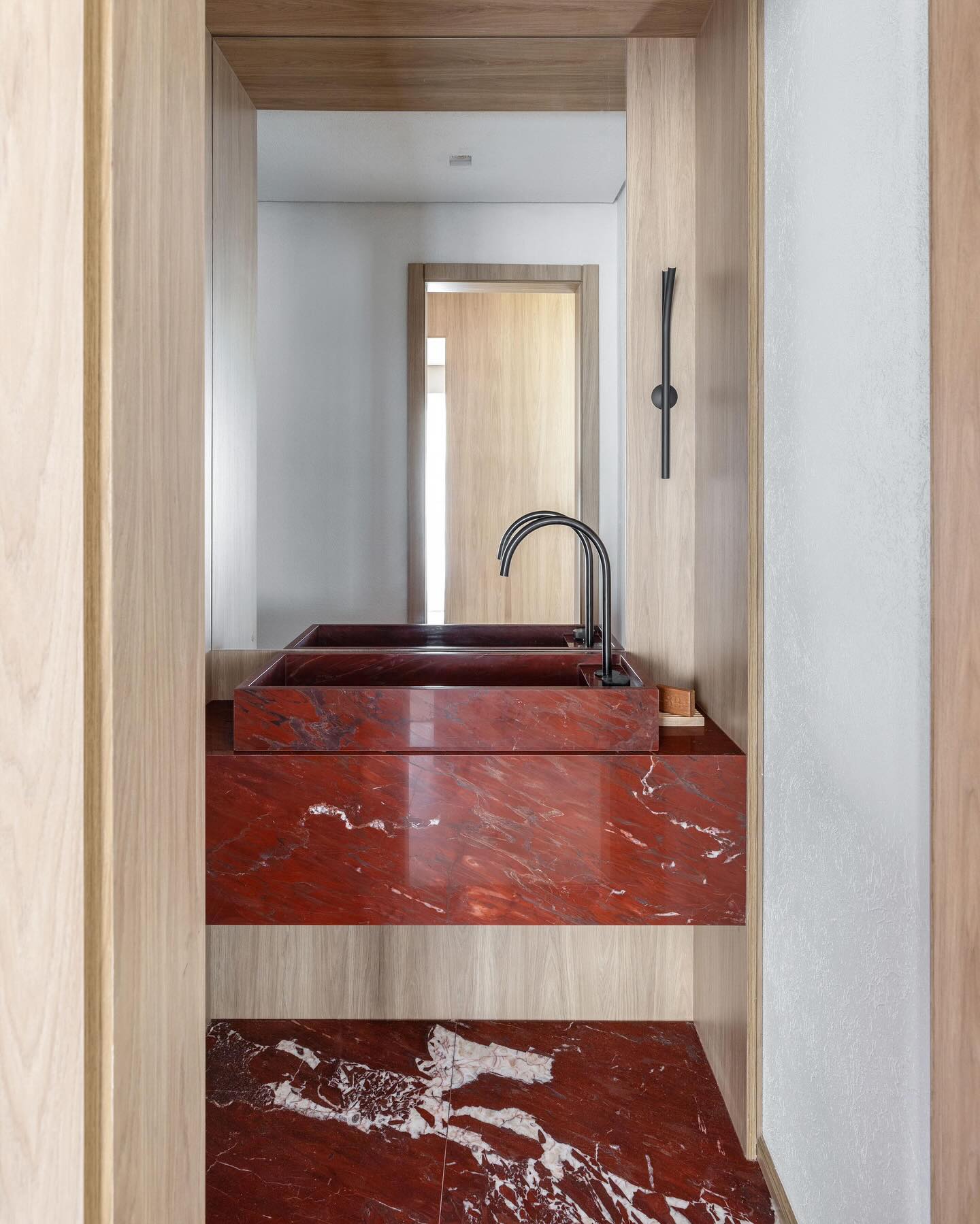 lavabo com cuba esculpida em mármore vermelho.