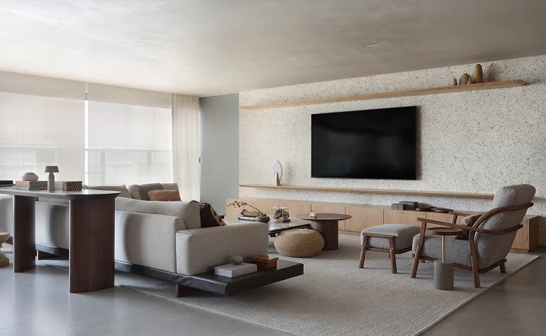 TV instalada em parede ampla com rack baixo e mobiliário proporcional, destacando o equilíbrio entre tela, painel e decoração.