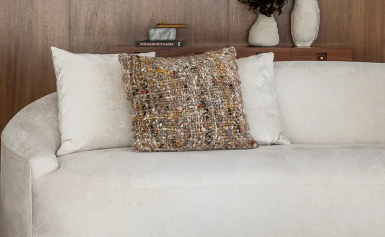 Almofadas decorativas em sofá claro, exemplo de peças que podem precisar de higienização completa conforme o tipo de enchimento.
