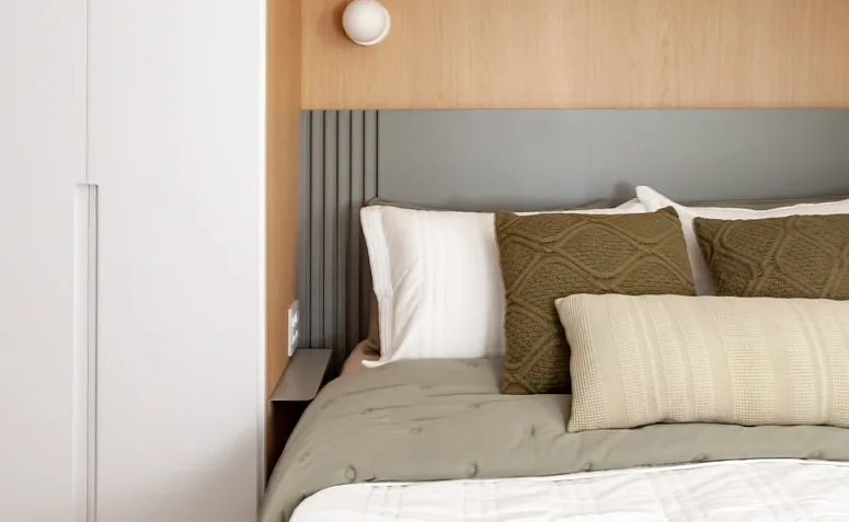 Almofadas sobre a cama, representando peças que devem ser substituídas quando perdem volume, conforto ou apresentam desgaste.