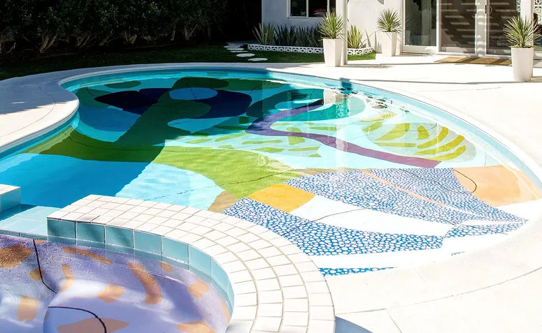Piscina com fundo colorido em formas orgânicas e padrões variados, criando efeito artístico e personalizado.