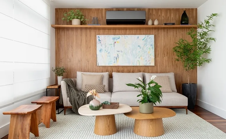 Lírio-da-paz em vaso com folhas verdes brilhantes e espatas brancas na decoração de sala de estar.