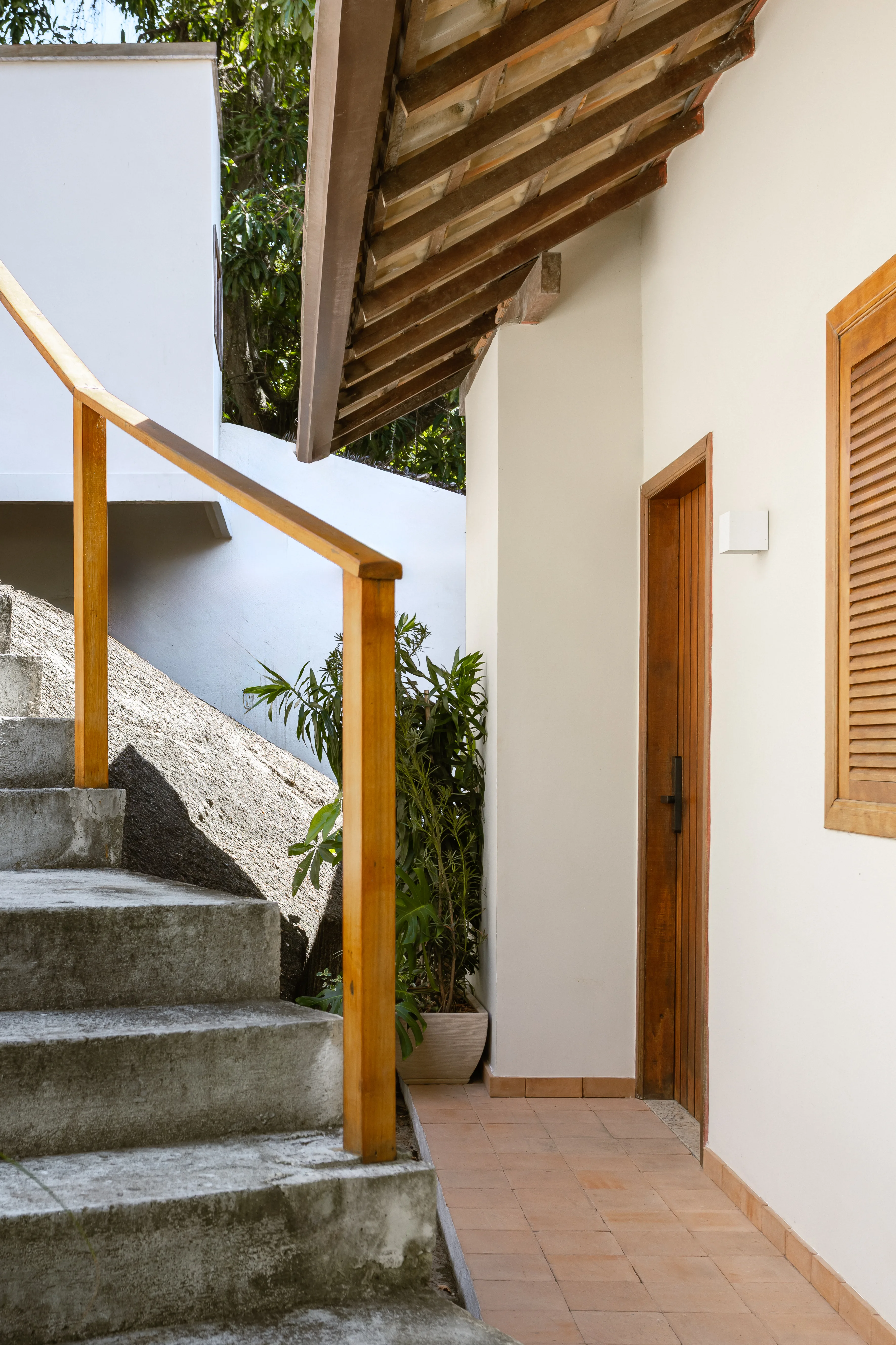 Casa brasileira com madeira, tons terrosos, varanda aberta e atmosfera leve para receber família e amigos.