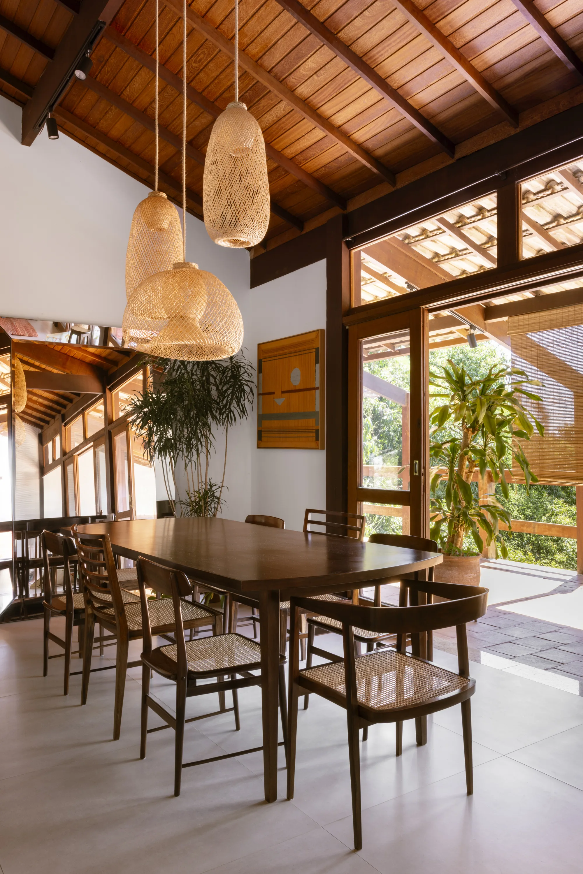 Detalhe do forro de madeira e da estrutura original preservada em casa reformada com clima rústico e natural.