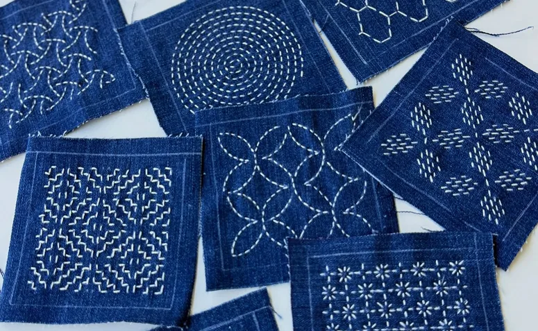 Bordado sashiko tradicional japonês com pontos manuais e padrão inspirado na natureza.