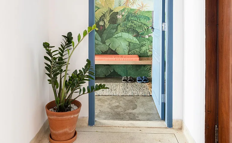 hall de entrada com banco e local para deixar os sapatos perto da porta.