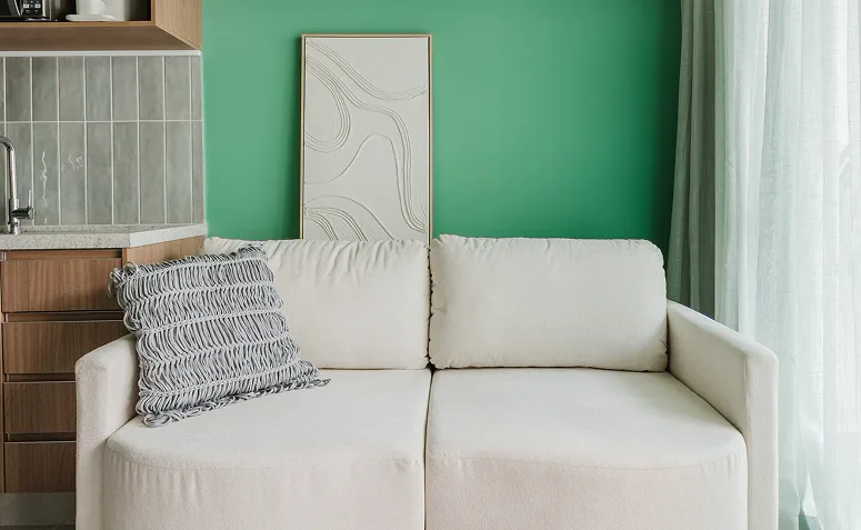 sofá claro em frente a parede verde em sala de estar contemporânea