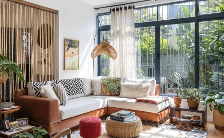 Sala de jantar boho com tapeçaria colorida, móveis de madeira, palhinha e plantas