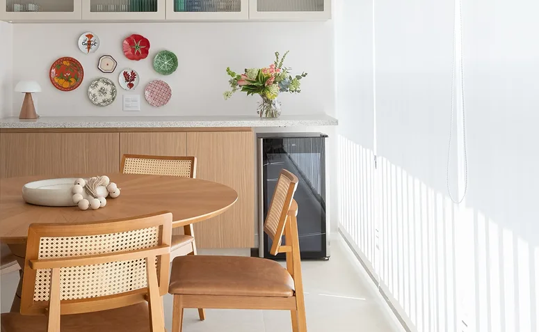 pratos decorativos coloridos pendurados em parede na varanda gourmet de apartamento.