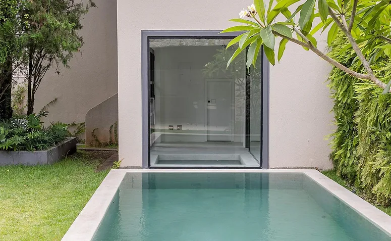 sauna residencial instalada ao lado da piscina e integrada ao jardim.